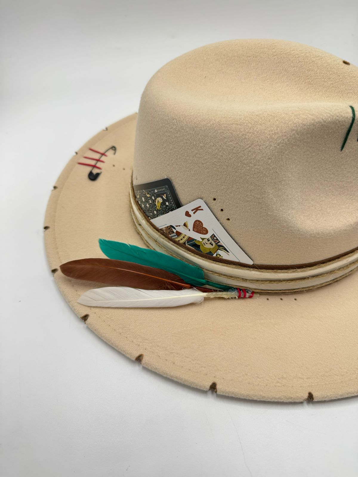 Beige fedora with cards and feathers