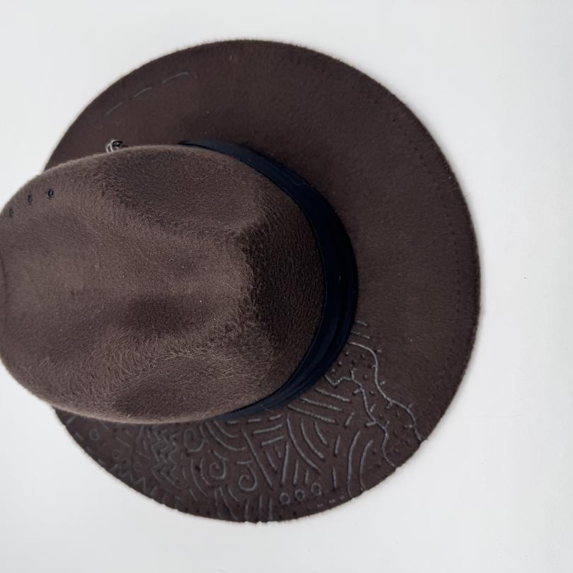 Dark brown fedora with hand carving and feathers