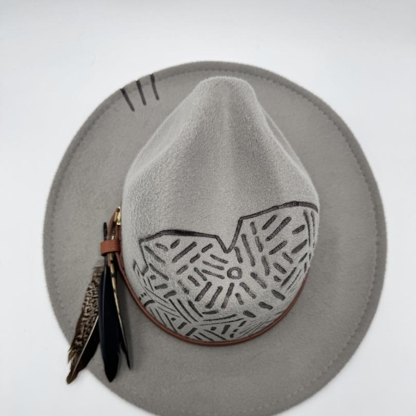 Grey fedora with carving and feathers