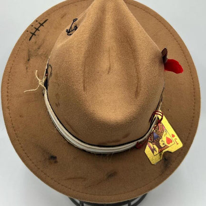 Brown fedora with red feather and gold card