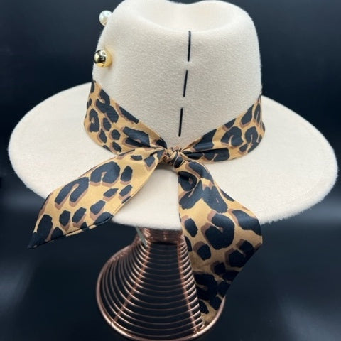 Elegant beige fedora with tiger print and pearl brooch